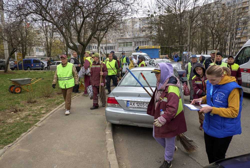 Комунальники прямують на місце обстрілу, щоб прибрати уламки біля пошкодженого вночі житлового будинку, Харків, 6 квітня 2024 р.