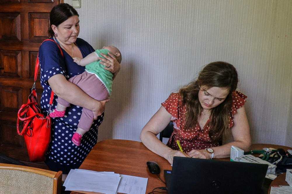 Місцева жителька з дитиною на прийомі в лікарки Марії з організації «Лікарі без кордонів» у селі Хотімля, Харківська обл., 5 липня 2023 року